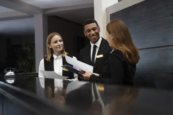 Recepcionistas uniformizados atendendo no balcão